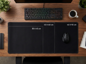Comparatif des dimensions de tapis de souris (35x45 cm, 40x60 cm, 40x90 cm) présentés sur un bureau en bois avec clavier et accessoires, pour visualiser l'espace de travail.