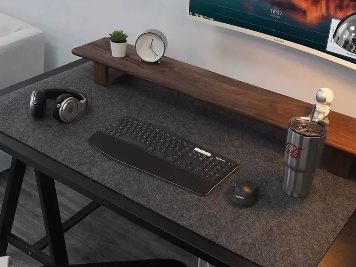 Grand tapis de souris noir sur bureau gaming sombre avec écran panoramique et clavier