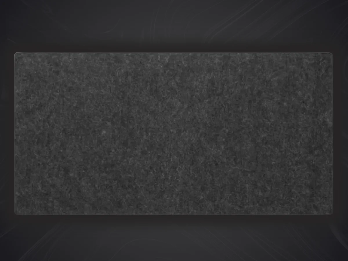 Gros plan d'un tapis de souris feutre de laine de forme rectangulaire de couleur anthracite ou gris foncé, sur un fond sombre.