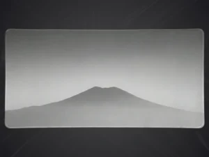 Grand tapis de souris minimaliste gris avec un dessin stylisé de montagne en niveaux de gris et bords cousus.